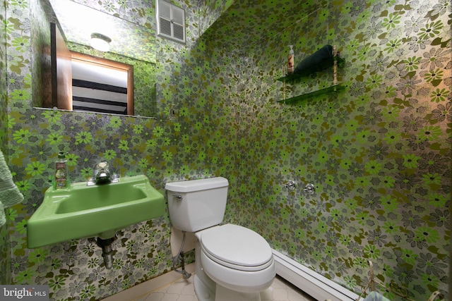 bathroom featuring baseboard heating, toilet, tile patterned flooring, and sink