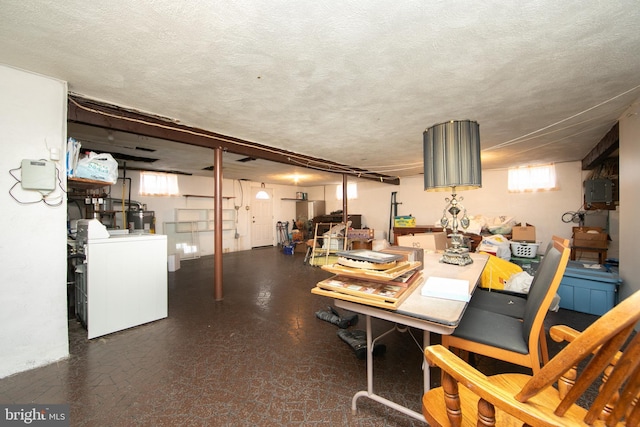 basement featuring washer / dryer, water heater, and a textured ceiling