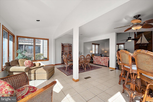 living room with light tile patterned floors, baseboards, and vaulted ceiling