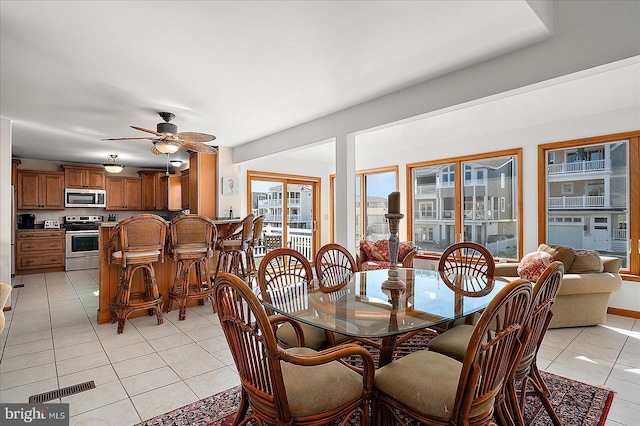 dining space with visible vents, ceiling fan, and light tile patterned floors