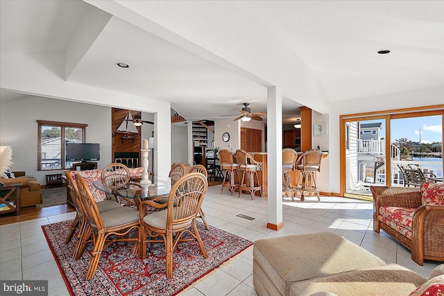 dining space featuring a ceiling fan, lofted ceiling, and light tile patterned floors