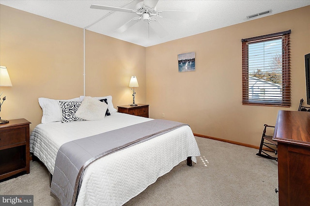 bedroom with a textured ceiling, carpet floors, a ceiling fan, visible vents, and baseboards