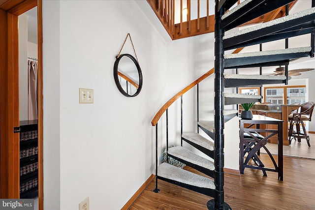 stairway featuring wood finished floors and baseboards