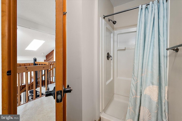 bathroom featuring curtained shower and a skylight