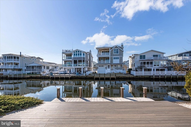 view of dock with a residential view and a water view