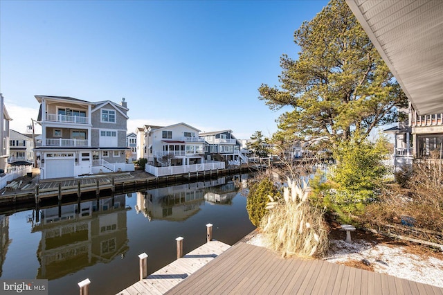 view of dock with a water view and a residential view