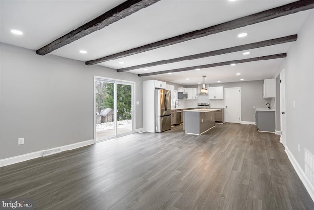 unfurnished living room with beamed ceiling, dark hardwood / wood-style floors, and sink