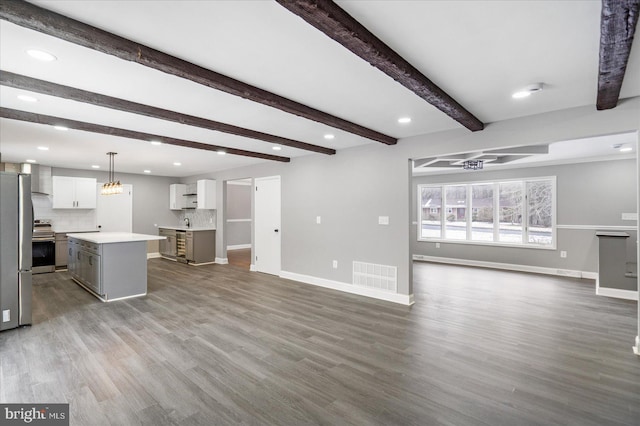 unfurnished living room featuring beamed ceiling and wood-type flooring