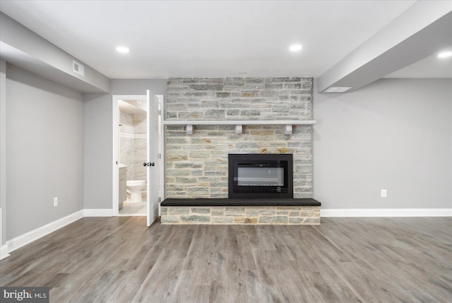 unfurnished living room with hardwood / wood-style floors and a large fireplace