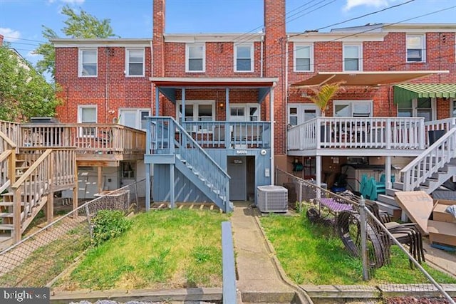 exterior space with a wooden deck, a front yard, and central air condition unit