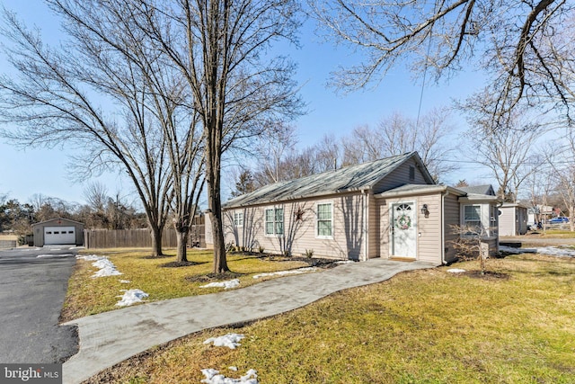 single story home with a garage, an outdoor structure, and a front yard