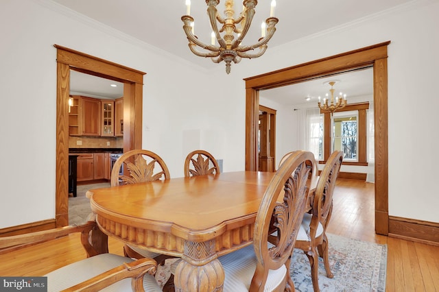 dining room featuring ornamental molding, light hardwood / wood-style floors, and a chandelier