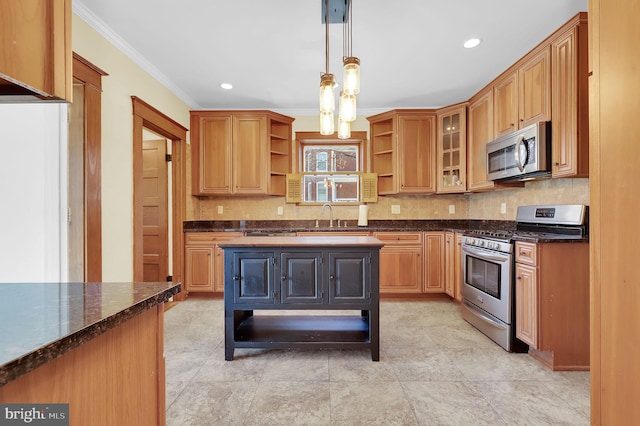 kitchen with appliances with stainless steel finishes, hanging light fixtures, dark stone counters, crown molding, and sink