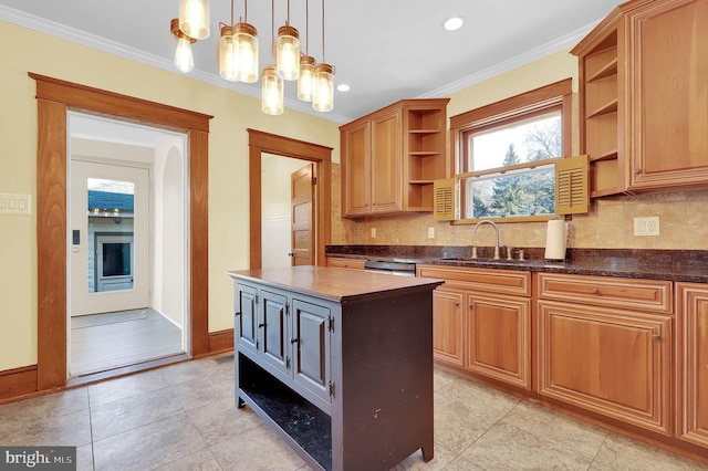 kitchen with hanging light fixtures, a center island, backsplash, ornamental molding, and sink