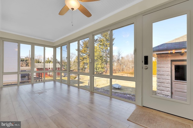 unfurnished sunroom featuring ceiling fan