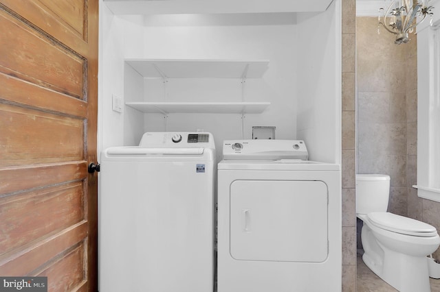 laundry room with tile walls and washing machine and dryer