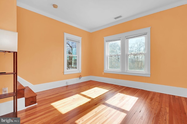 unfurnished room with ornamental molding and hardwood / wood-style floors