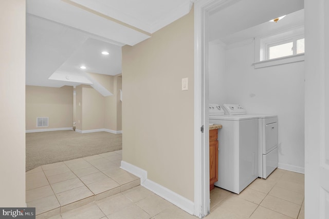 laundry area with washing machine and clothes dryer and light tile patterned flooring