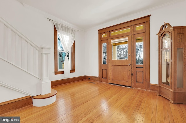 entryway with hardwood / wood-style floors and crown molding