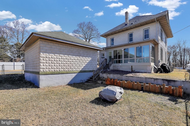 back of property with a sunroom and a lawn