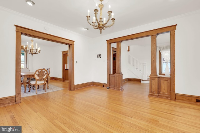 dining room featuring light wood-type flooring, crown molding, and an inviting chandelier