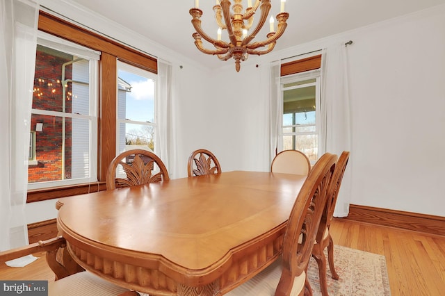 dining area featuring an inviting chandelier, light hardwood / wood-style flooring, and crown molding