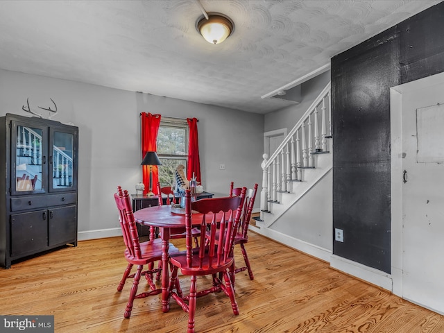 dining space with wood-type flooring