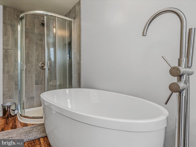 bathroom featuring hardwood / wood-style flooring and separate shower and tub