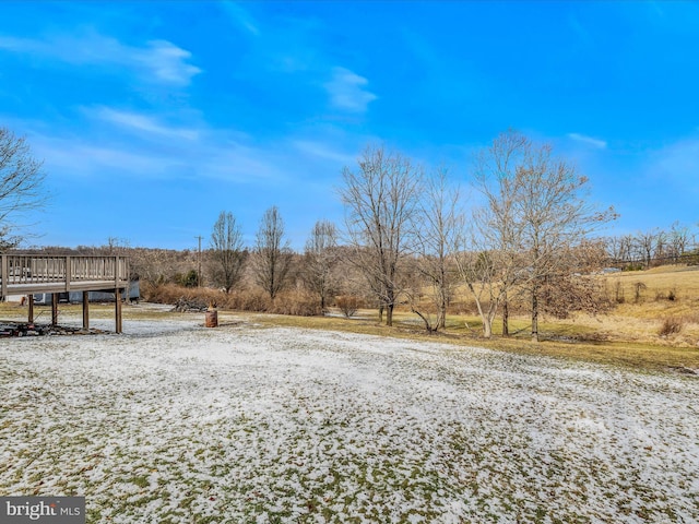 view of yard with a wooden deck and a rural view