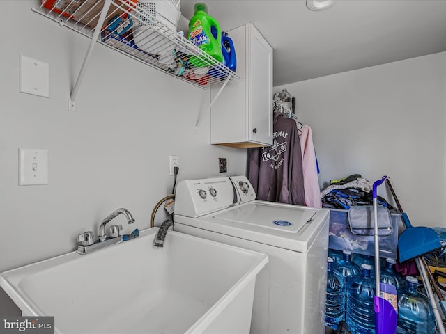 clothes washing area featuring washer / clothes dryer, sink, and cabinets