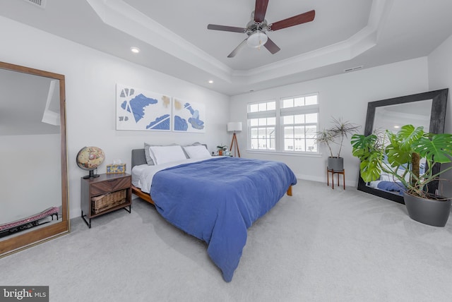 carpeted bedroom featuring crown molding, ceiling fan, and a tray ceiling