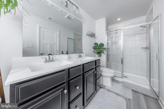 bathroom with vanity, toilet, and a shower with shower door