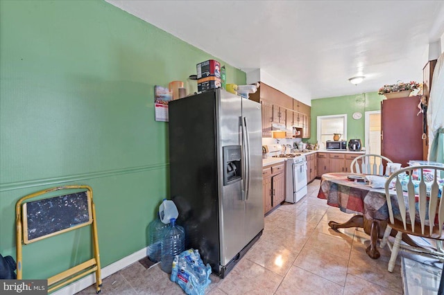 kitchen featuring stainless steel appliances and light tile patterned flooring
