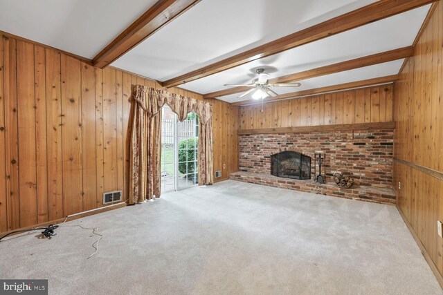 11919 Berrybrook Ter, Upper Marlboro, MD 20772 - unfurnished living room with beam ceiling, wooden walls, carpet, a brick fireplace, and a ceiling fan