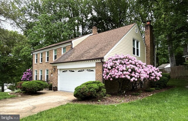 11919 Berrybrook Ter, Upper Marlboro, MD 20772 - colonial home with a chimney, driveway, an attached garage, a shingled roof, and brick siding