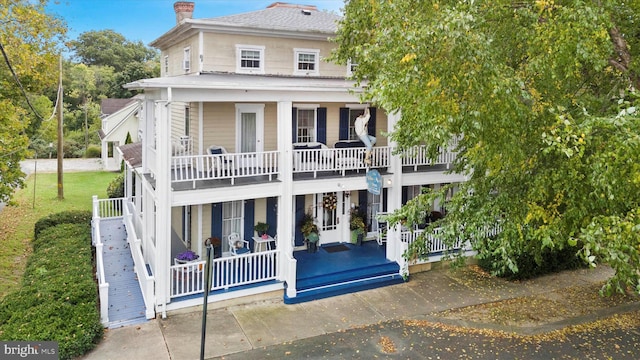 back of house featuring a balcony and covered porch