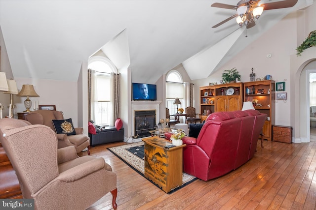 living room with ceiling fan, vaulted ceiling, and light hardwood / wood-style flooring