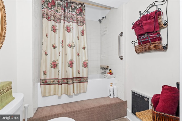 bathroom featuring toilet, heating unit, and shower / bath combo