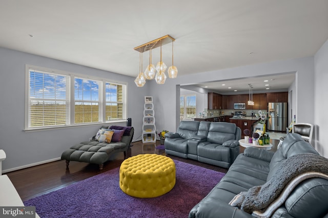 living room featuring plenty of natural light and dark hardwood / wood-style flooring