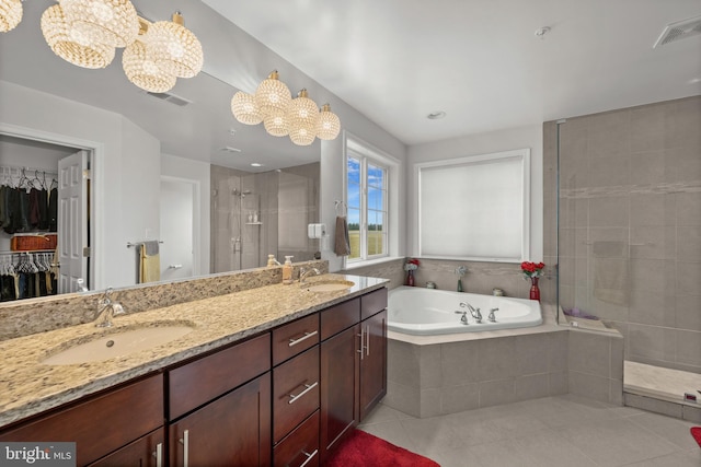 bathroom featuring tile patterned flooring, vanity, shower with separate bathtub, and a chandelier