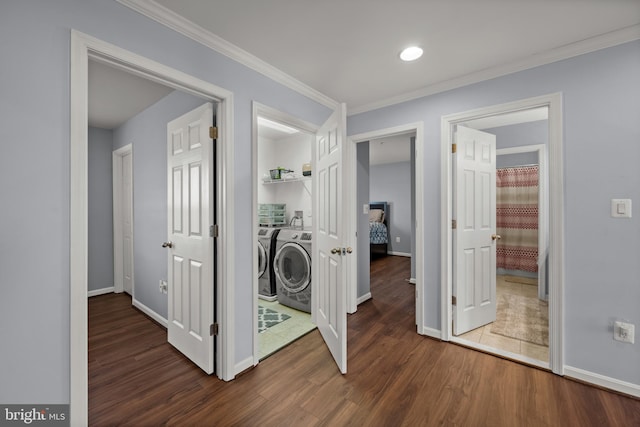 corridor with dark hardwood / wood-style flooring, ornamental molding, and independent washer and dryer