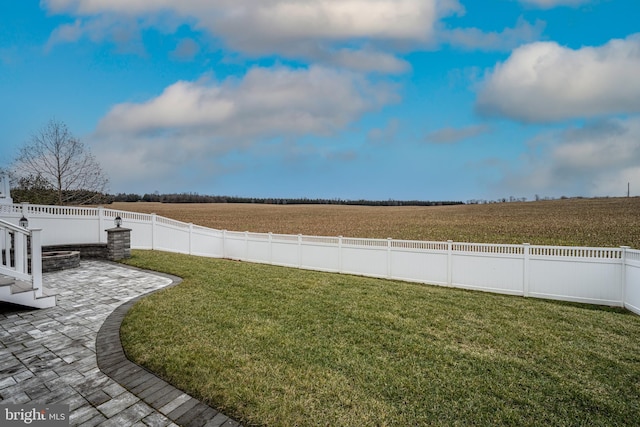 view of yard with a rural view and a patio