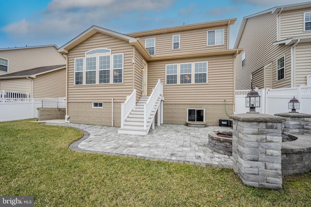 back of property with a patio, a fire pit, and a lawn