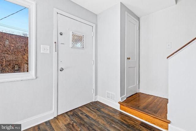 foyer featuring dark wood-style floors, stairway, visible vents, and baseboards