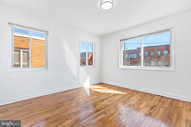 empty room with wood-type flooring and baseboards