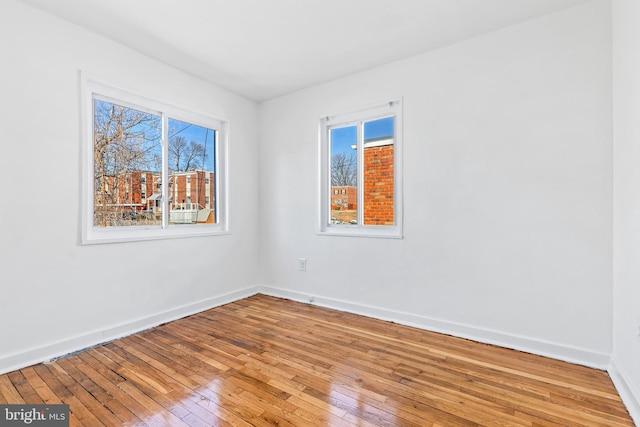 empty room featuring baseboards and hardwood / wood-style floors