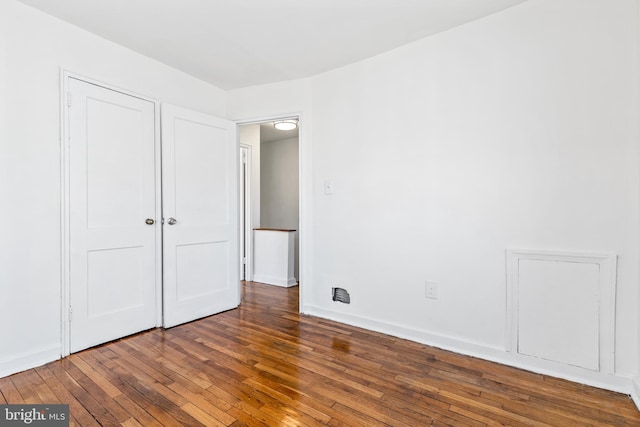 unfurnished bedroom featuring dark wood-style flooring and baseboards