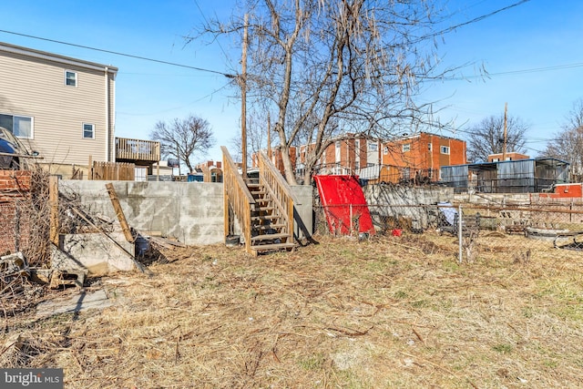 view of yard with stairs and fence