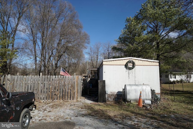 view of outbuilding with heating fuel and fence