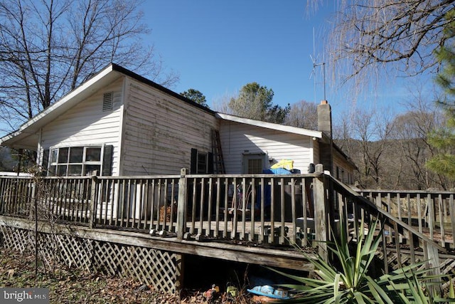 exterior space featuring a chimney and a wooden deck